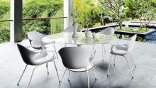 Elephant chairs surrounding circular table in outdoor environment.