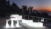 SLIDE: Break Bar luminous bar counter, Voilà stools paired with a Hoplà high table, curved Ypsilon modular and luminous benches, and Cono floor lamps.