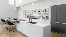 Valcucine Demode kitchen in island configuration with integrated table and Meccanica shelving.