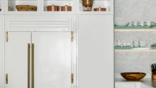 Built-in True refrigerator surrounded by glossy white glass cabinetry.
